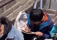 男孩坐长城上写作文 景区回应不建议这么做会影响大家的通行