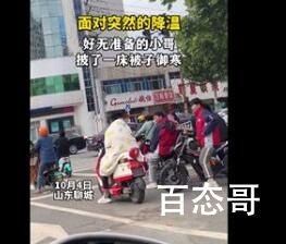 山东断崖式降温 小伙披被子骑车 猝不及防的温暖：棉被加身